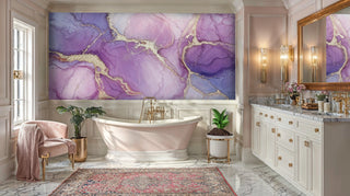 Purple and pink marble wall mural with gold veining in a luxe bathroom with pink armchair and rug