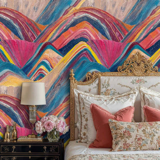 Rainbow geometric wallpaper featuring flowing peaks behind ornate gold bed frame with coral pillows