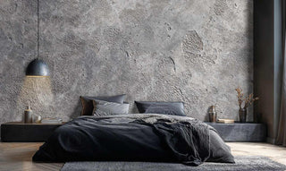Raw concrete texture wallpaper featuring organic surface variations in neutral grey, displayed in modern bedroom setting