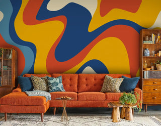 retro abstract wallpaper featuring flowing organic shapes in blue, orange, and yellow, styled in living room with orange sofa