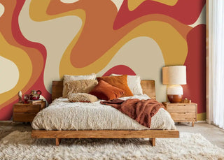 Retro abstract wallpaper with flowing red and orange shapes in warm bedroom with wooden bed frame