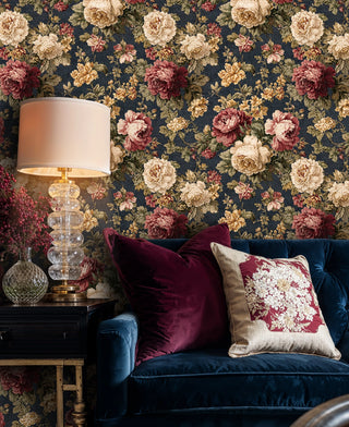 rich botanical wallpaper with detailed roses and peonies, shown in living space with crystal lamp
