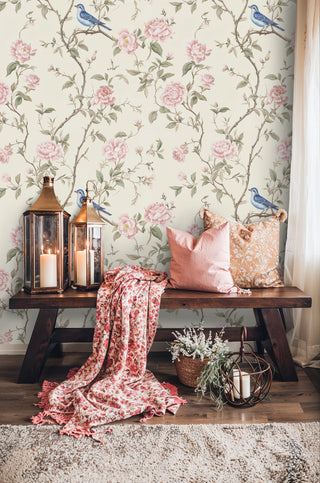 Romantic floral wallpaper showing pink roses and blue songbirds, styled in living room with copper lanterns