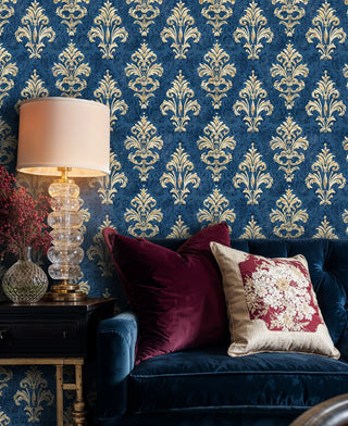 Royal navy damask wallpaper with gold ornamental motifs, displayed in sophisticated living room with crystal lamp