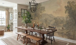 Rustic landscape wall mural with cattle grazing by river in warm earth tones, displayed in modern farmhouse dining room with wooden table and bench seating