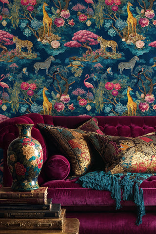 Safari garden wallpaper with tigers, giraffes, and tropical blooms on teal, styled in luxurious living room with burgundy velvet sofa