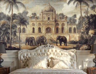 Scenic elephant palace wall mural in warm beige tones, behind an ornate white tufted bed with ivory linens and lamps