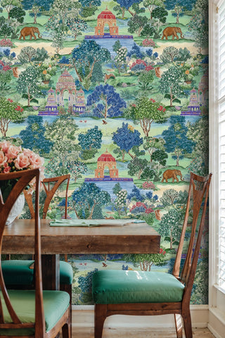 Scenic Indian garden wallpaper with elephants and flowering trees in green and blue, in a dining room with rustic wooden table