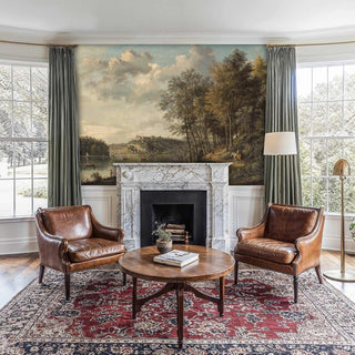 Scenic landscape wall mural featuring peaceful river and hillside castle, displayed above marble fireplace