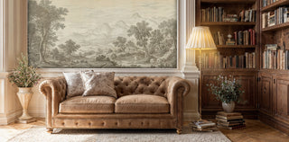 Scenic mountain wall mural in vintage style, displayed in traditional study with leather sofa and built-in bookshelves