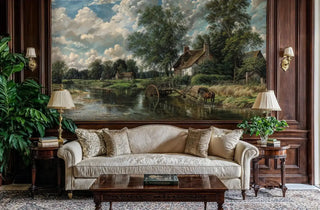Scenic river landscape Wall Mural with pastoral cottages, shown in a formal living room with dark wood paneling and a classic beige sofa.