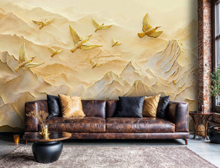 Sculptural gold birds over layered peaks wall mural in warm tones, displayed in an industrial loft with leather sofa