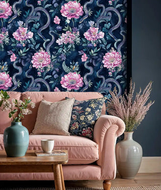 Serpentine garden wallpaper with pink peonies and navy serpents, shown in living room with dusty pink sofa