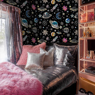 Sparkling cosmic wallpaper with gem-studded planets and stars, shown in glamorous bedroom with metallic bedding