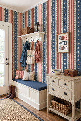 Stars and stripes folk wallpaper in red blue and cream shown in a farmhouse entryway with coat hooks and bench