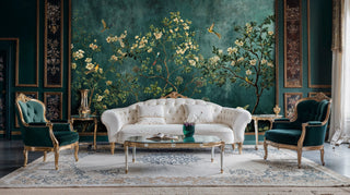 Teal chinoiserie wallpaper with flowering branches displayed in formal sitting room with white tufted sofa