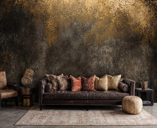 Textured metal wallpaper with golden accents in sophisticated living room with moroccan ottoman