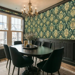 Traditional damask wallpaper with gold detailing on green base in modern dining space with black round table