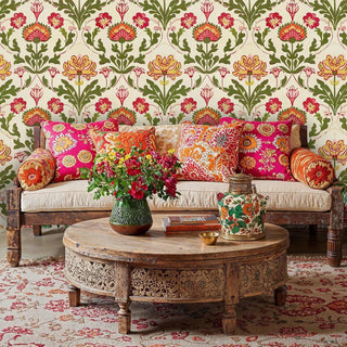 Traditional floral damask wallpaper with coral and yellow blooms in maximalist living room with ornate coffee table