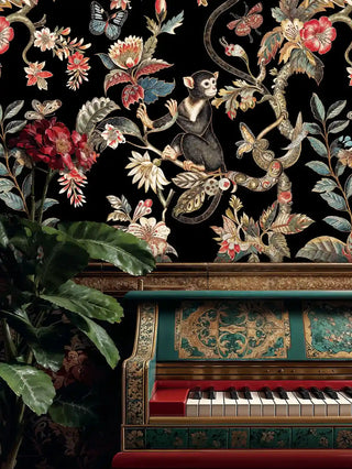 Tropical animal wallpaper featuring monkeys and vibrant florals displayed above ornate vintage piano with brass details