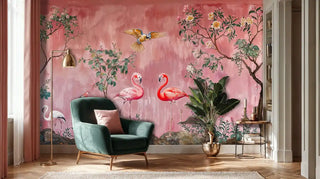 Tropical birds wall mural with flamingos and parrots on coral pink background, shown in modern living room with velvet chair