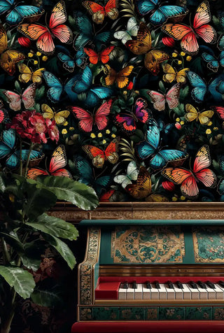 Tropical butterfly wallpaper with vibrant blue, coral and yellow butterflies on black, displayed behind ornate piano