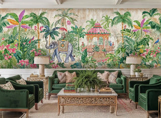 Tropical elephant wall mural with pink hibiscus and palm trees in elegant living room with green velvet sofa