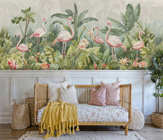 Tropical flamingo wall mural with pink birds among green palm leaves, displayed in modern living room with leather sofa