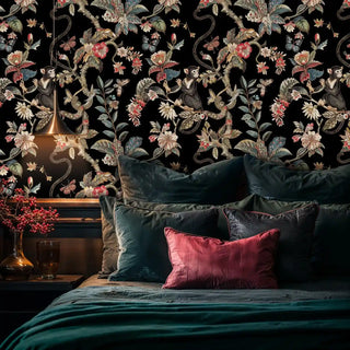 Tropical floral wallpaper with playful monkeys and ornate vines shown in luxurious bedroom with emerald velvet bedding