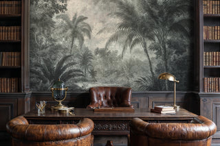 Tropical jungle wall mural with dense palms and engraved foliage, shown in a dark library with leather chairs