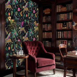 Tropical mystical wallpaper showing flying leopards among palm fronds in classic library with burgundy armchair