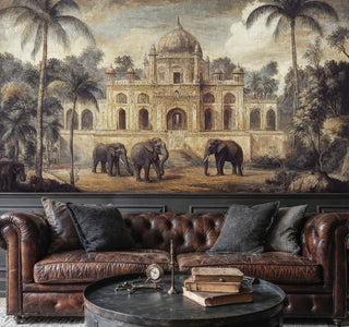 Tropical palace mural with elephants in muted gold and green, above a brown chesterfield sofa with a round coffee table