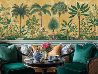 Tropical paradise wall mural with palm trees and exotic birds on golden background, shown in elegant sitting area with green velvet furniture