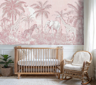 Tropical safari wall mural featuring wildlife and palm trees in blush tones, shown in elegant nursery with wooden crib