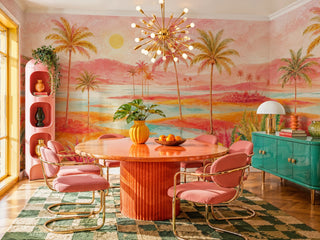 Tropical sunset wall mural with palm trees and turquoise lagoon in a bold dining room with sputnik chandelier