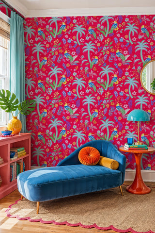 Tropical toucan and floral wallpaper on fuchsia ground, in a reading nook with blue velvet chaise lounge