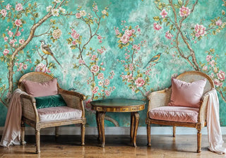 Turquoise bird and flower wall mural in sitting area with cane chairs and pink velvet cushions