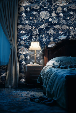 Underwater adventure wallpaper with fish and octopi, displayed in cozy bedroom with warm bedside lamp