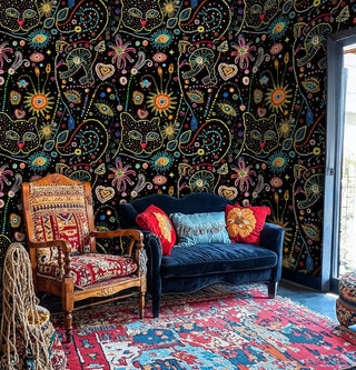Vibrant cosmic wallpaper with dotted sun and heart patterns, displayed in eclectic sitting room with carved wooden chair