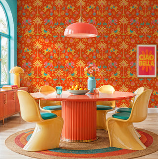 Vibrant orange tiger and palm wallpaper with pink and teal accents, in a retro dining room with round table