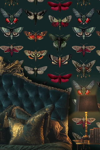 Victorian moth and butterfly wallpaper in rich emerald and burgundy tones, shown in luxurious bedroom with velvet headboard