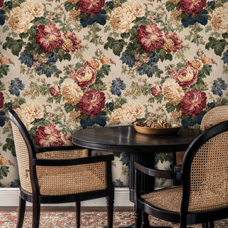 Vintage botanical wallpaper featuring layered florals, shown in intimate dining area with cane-back chairs