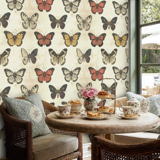 Vintage butterfly wallpaper with coral and cream specimens in rustic dining nook with wicker chairs and tea service