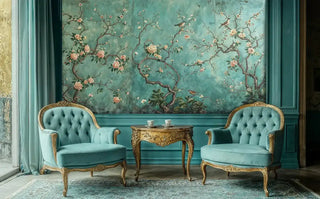 Vintage Chinoiserie Wall Mural with pink blossoms and birds on a teal background, in a classic room with two tufted teal armchairs.