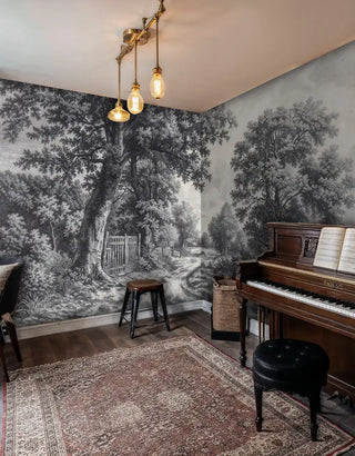 Vintage countryside wallpaper featuring detailed trees and wooden gate in grey tones, shown in music room with piano