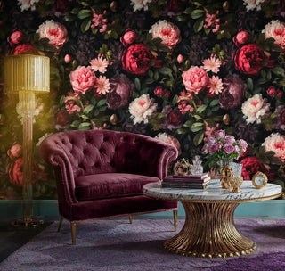 Vintage floral wallpaper with dramatic peonies behind a tufted velvet armchair and a round marble coffee table in a glam living room.