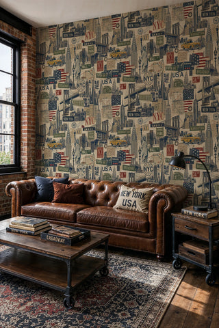 Vintage NYC collage wallpaper with landmarks and taxi cabs in beige and navy, in an industrial loft with leather Chesterfield sofa