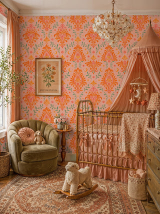 Warm damask wallpaper with coral scrolls and golden moons, in a nursery with brass crib and canopy