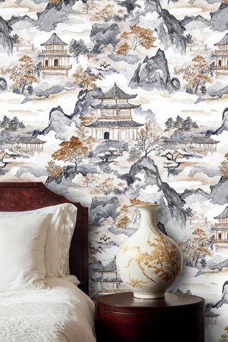Watercolor pagoda wallpaper with misty mountains and golden trees in a bedroom with ceramic vase
