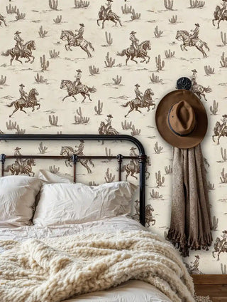 Western cowboy wall mural featuring horsemen and desert cacti in sepia tones, shown in rustic bedroom with iron bed frame